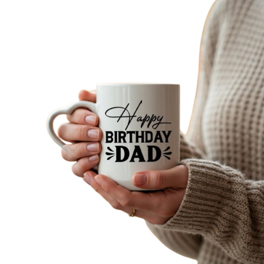 Hands holding the heart-handle mug with “Happy Birthday Dad” in black script and capitals