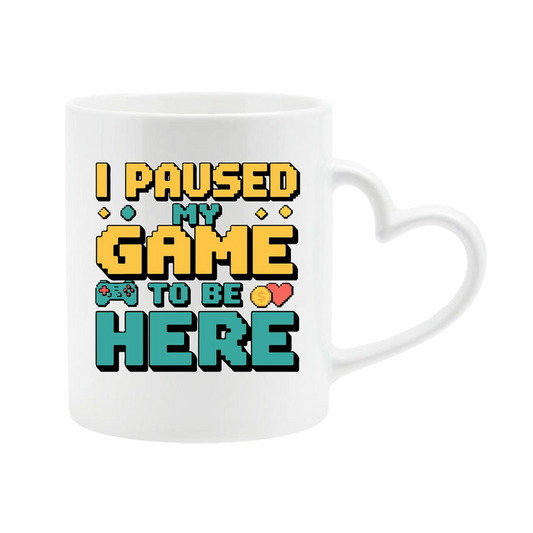 White heart-handle mug with retro “I Paused My Game to Be Here” lettering