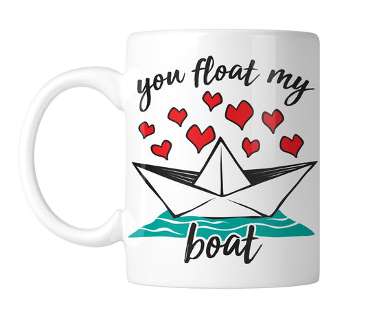 White mug with a paper boat, red hearts and “You Float My Boat”, handle on the left