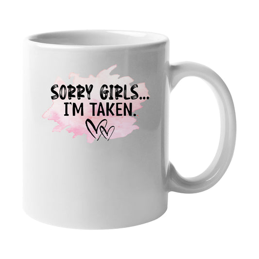 White mug with “Sorry Girls, I'm Taken” with a pink heart